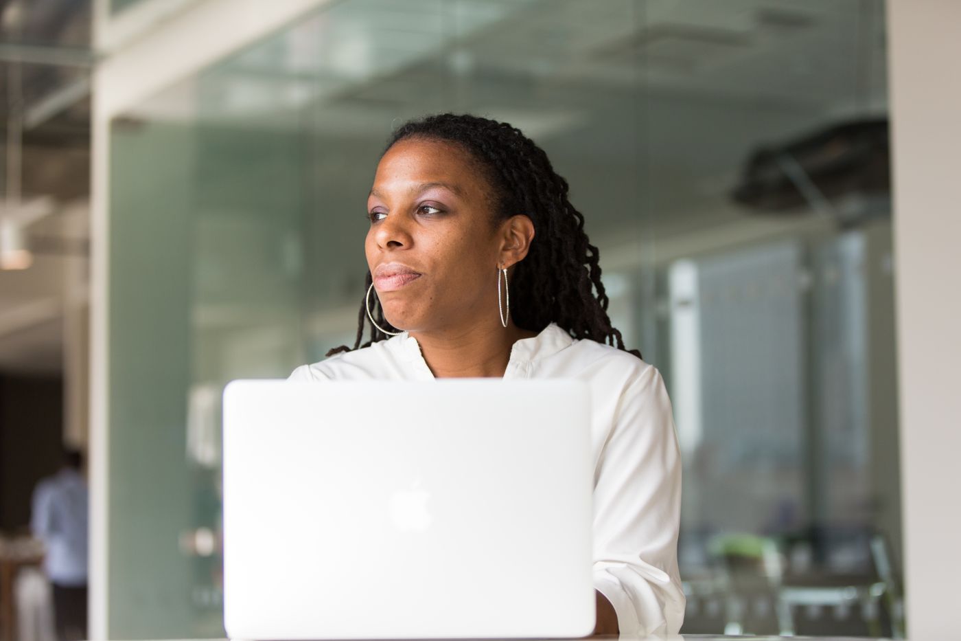A professional focused on her laptop in a modern workspace